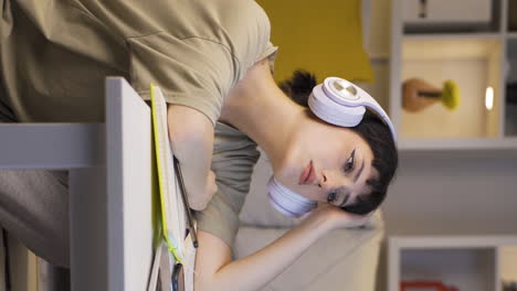 Vertical-video-of-Depressed-young-woman-listening-to-music-at-home-at-night.